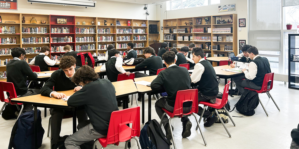 Photo of Chaminade students tutoring their students in the library