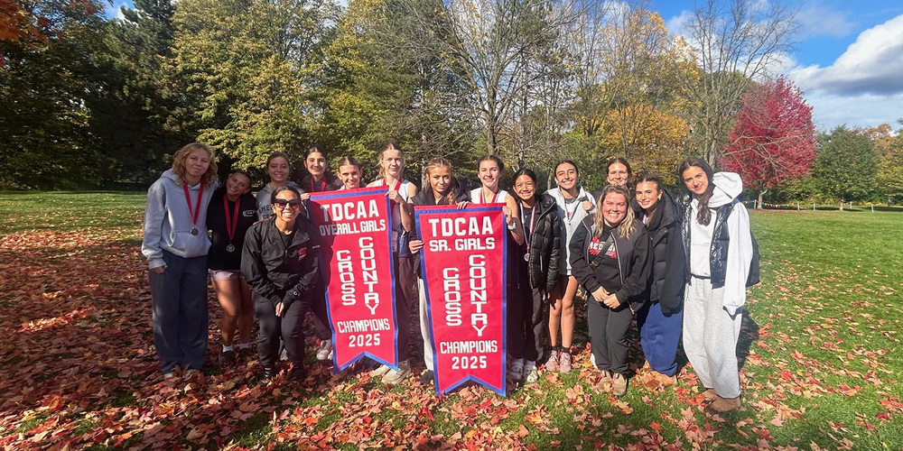 Group photo of the Father John Redmond cross country team with their TDCAA Overall Girls and Senior Girls championship banners