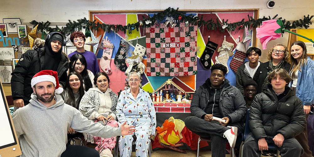 Group photo of Monsignor College Annex students and staff together with the display they built