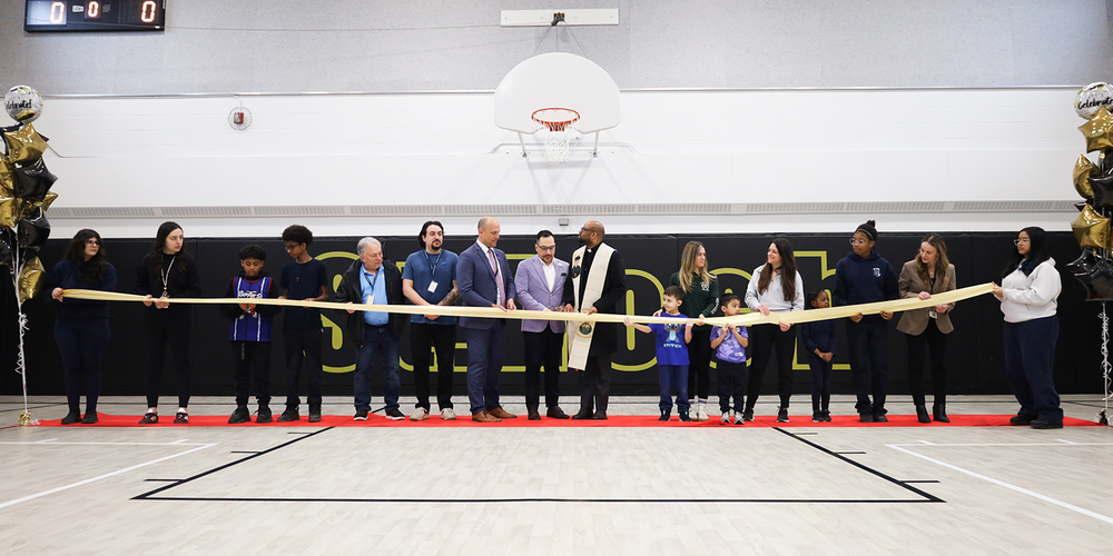 Photo of St. Roch staff and students along with TCDSB senior staff cutting the ribbon on the newly renovated gym