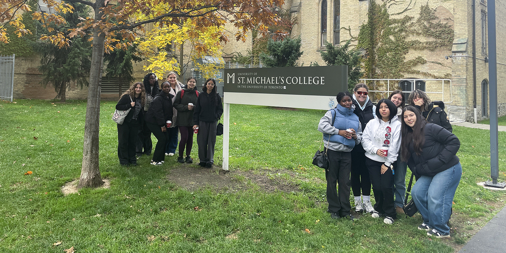 Group photo of Loretto College School students in front of the St. Michael's College sign