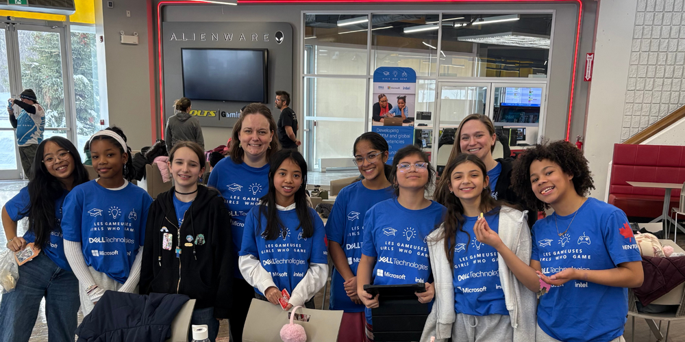 A group of girls in blue shirts that say "girls who game"