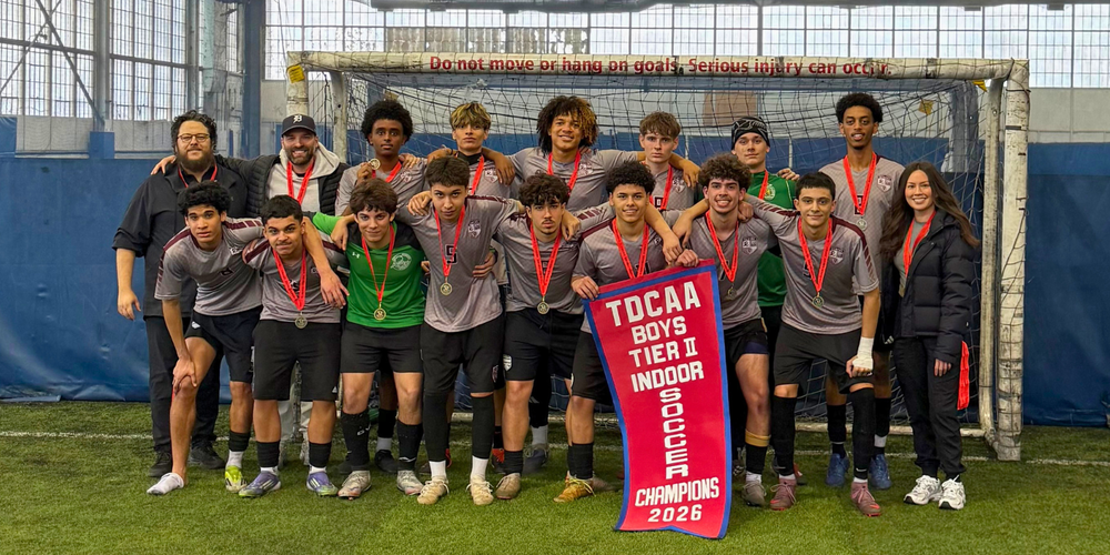 Soccer team posing with Champions Banner 