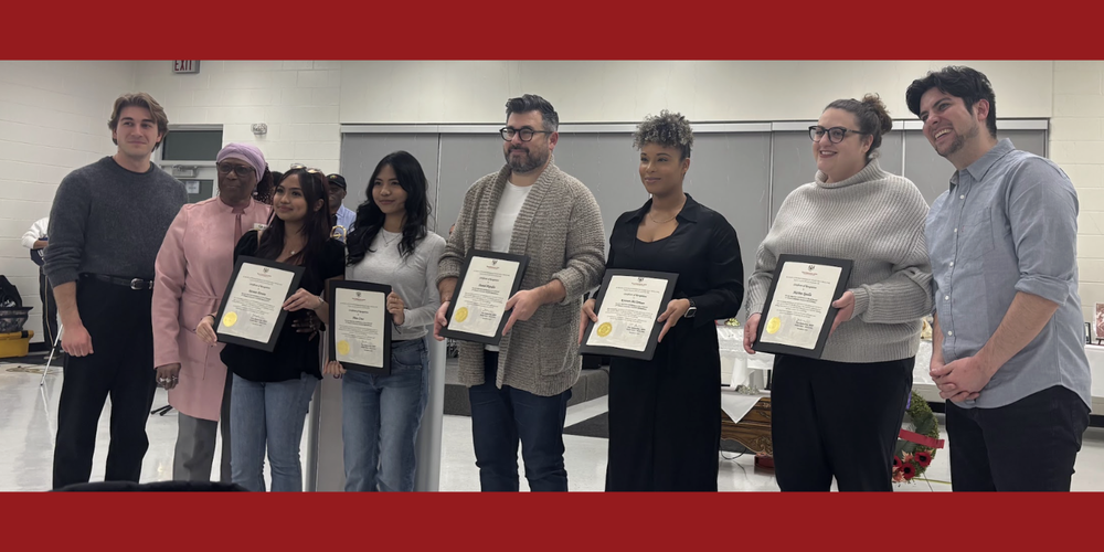 A group of people holding awards/certificates.