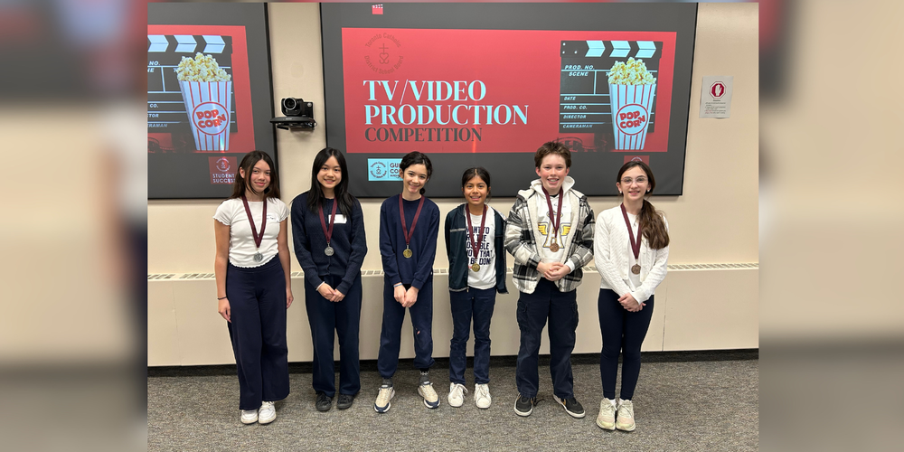 6 young students posing in front of projector that reads "TV Video Production Competition"