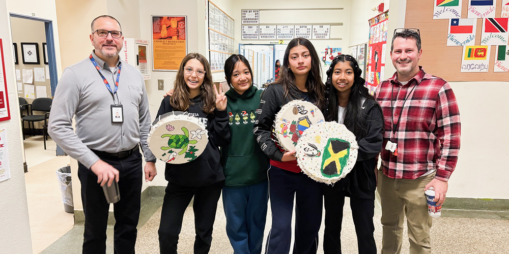 Photo of St. Theresa Shrine students posing with the drums they painted and TCDSB staff