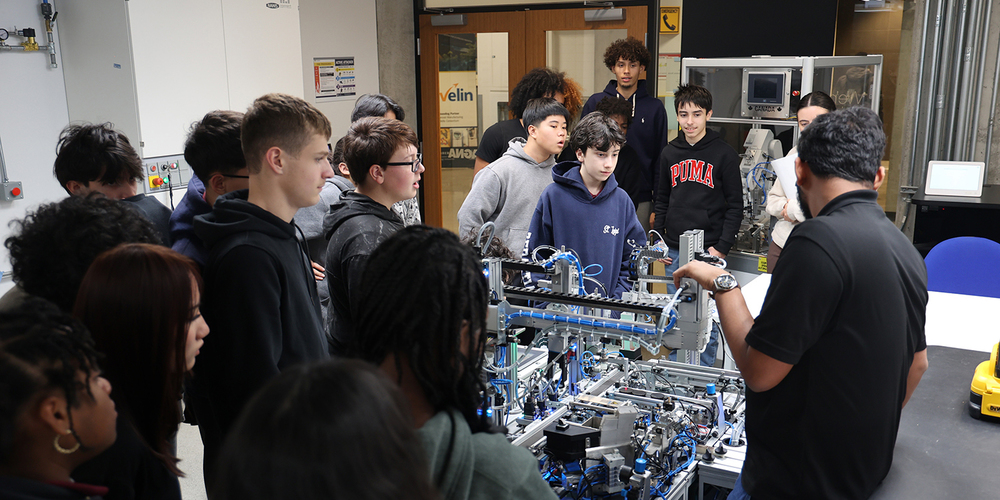 Photo of St. Oscar Romero students watching a robotics rig