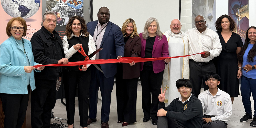 Photo of Dante staff and students at the opening and blessing gathered around the red ribbon, accompanied by TCDSB senior staff, the pastor and other attendees.