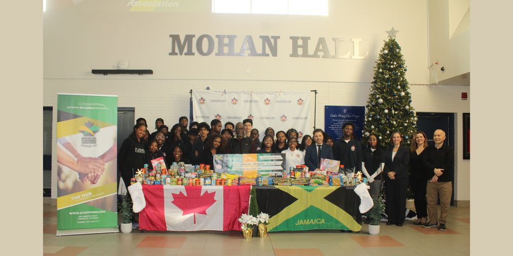 Group photo in front of tables with the Canada and Jamaica flag draped on the tables. 