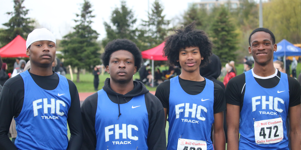4 students posing outdoors in FHC Track jerseys