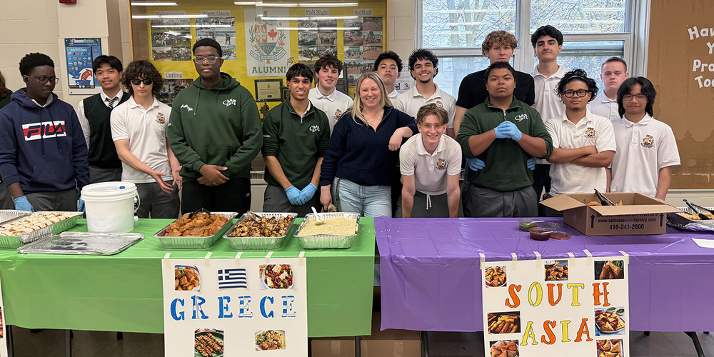 Photo of Chaminade students and staff sanding in front of the Greek and South Asian cultural tables
