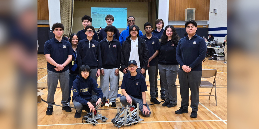 A group of students with 2 small robots. 