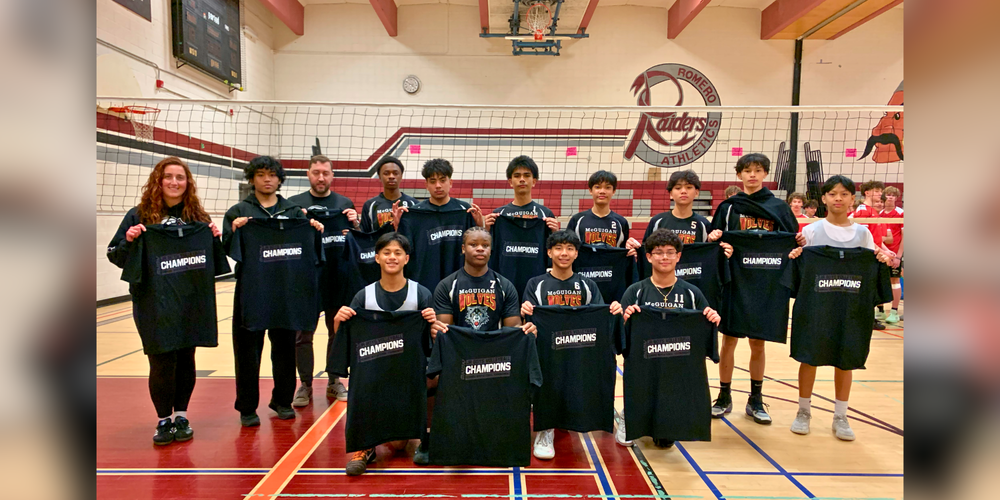 Volleyball team posing with CHAMPIONS shirts.