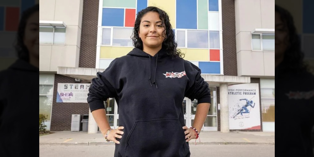 Photo of JCM student Kiara in front of the JCM school building