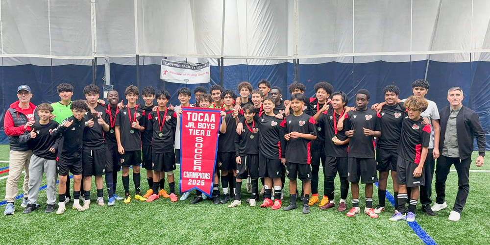 Group photo of Brebeuf team and coaching staff with the TDCAA championship banner