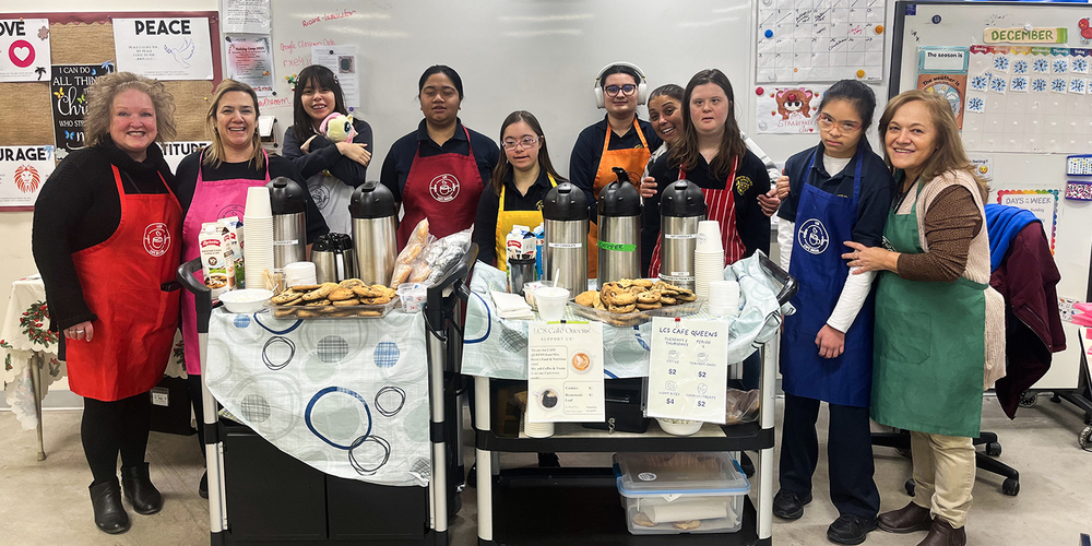 Photo of Loretto College students and teachers with their cart full of baked goods