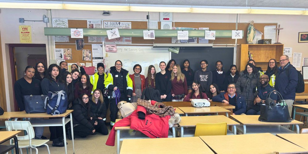Large group of students and paramedics in a classroom. 