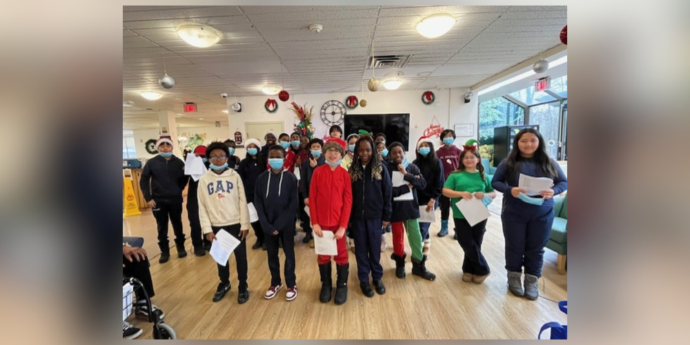 A group of students in a room with masks on and some Christmas decorations