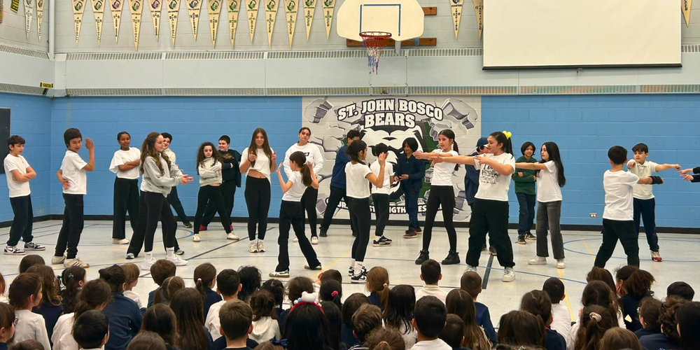 Large group of students dancing in a gym.