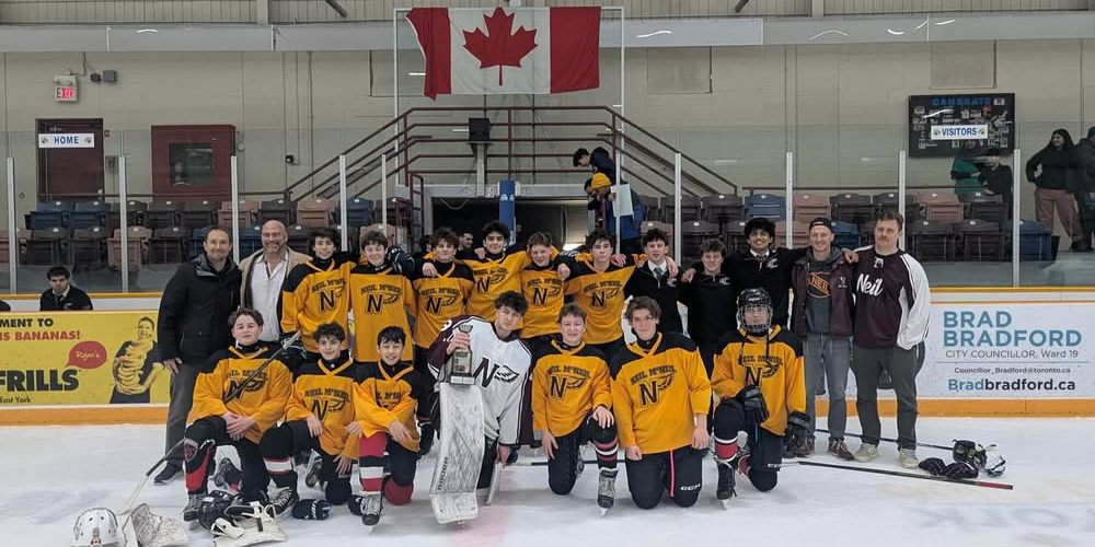 Photo of Neil McNeil team on the ice with their trophy