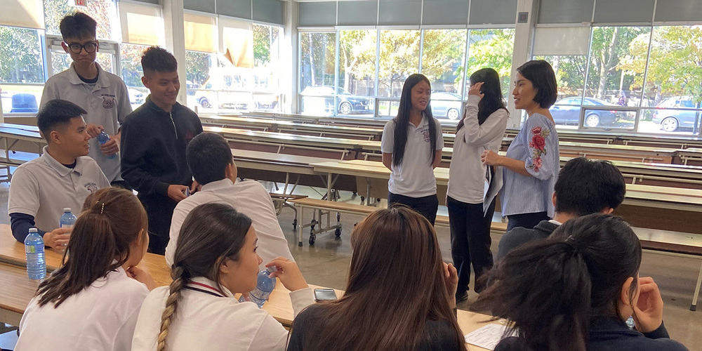 Photo of JCM staff and new English Language Learner students conversing together at the Meet-and-Greet
