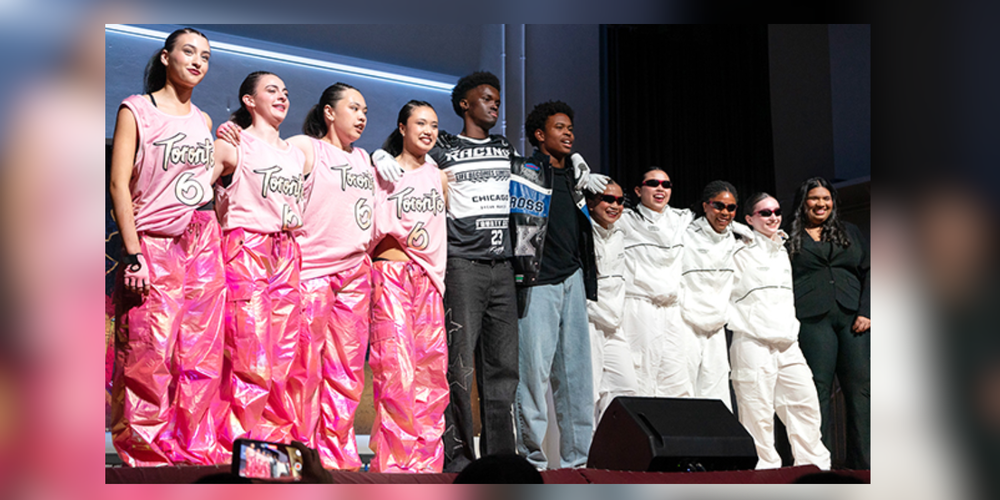 Students standing on a stage in dance costumes