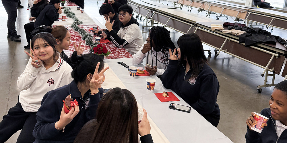 Photo of James Cardinal McGuigan's newcomer students enjoying snacks and warm drinks