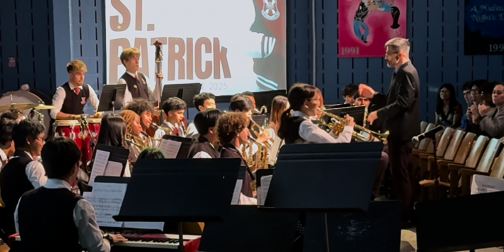 Photo of St. Patrick music students being conducted in their performance by their teacher