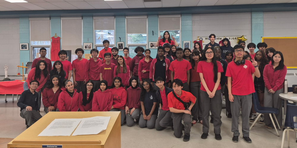 Large group photo of students in red shirts.
