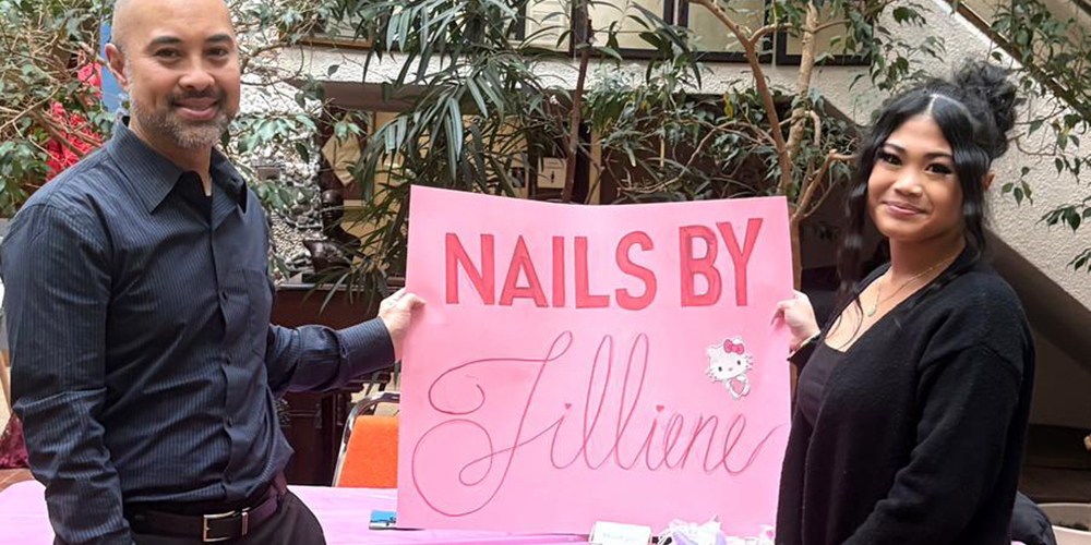 Photo of Jillian with Michael Consul holding up the poster advertising her business