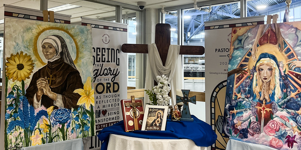 Banner showing Mary display with two paintings and other Mary-related displays and crosses