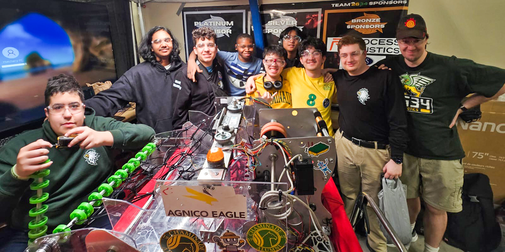 Group photo of the Chaminade Robotics team with the machine that they built