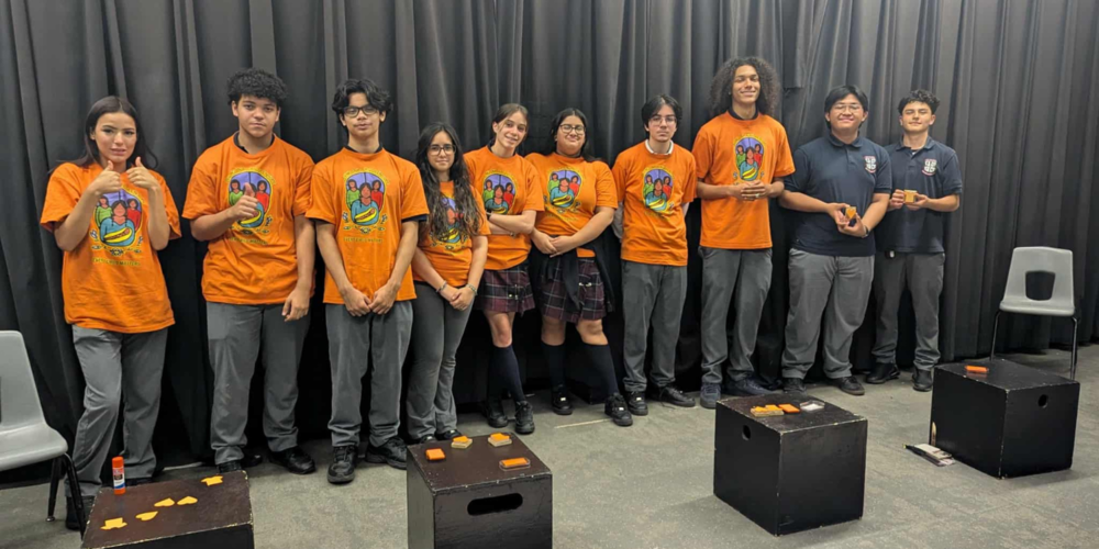 Students in orange shirts posing  in a group photo