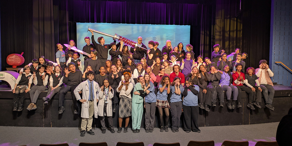 Group photo of the student performers on stage