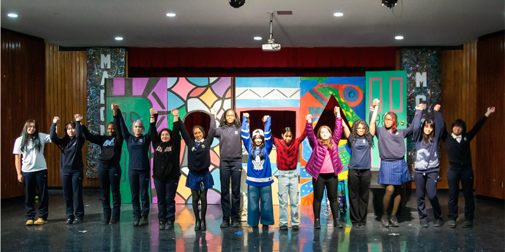 Photo of Madonna drama performers and back end team together on the stage