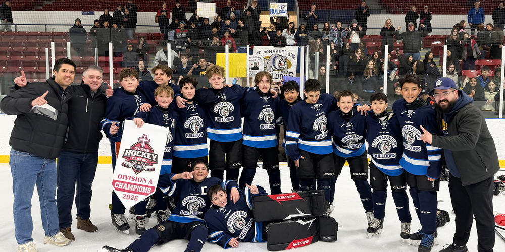 Group photo of the St. Bonaventure ice hockey team on the ice with their championship banner