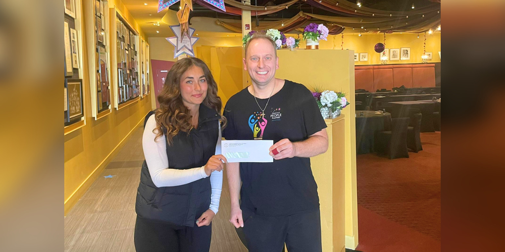 A man and a woman holding an envelope together.