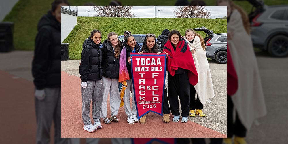 Group photo of the Notre Dame High School track and field team posing with their TDCAA championship banner