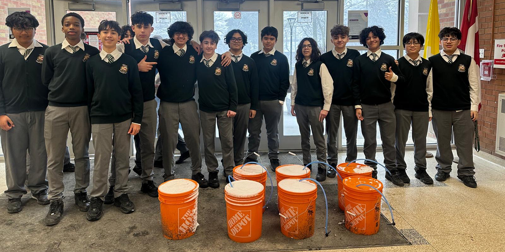 Group photo of Chaminade students with the syrup they collected