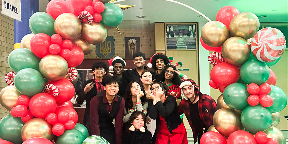 Photo of St. Basil-the-Great students under a Christmas colors themed balloon arch