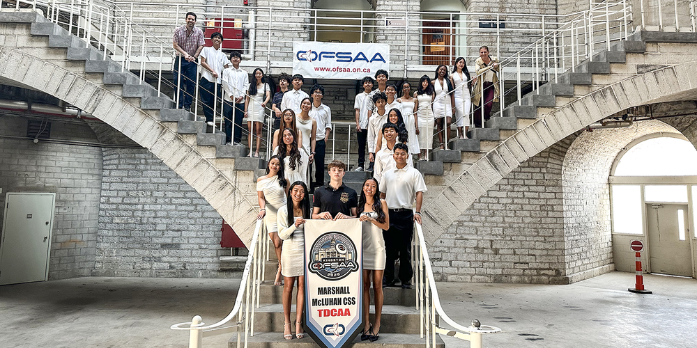 Group photo of the Rebels team with their championship banner