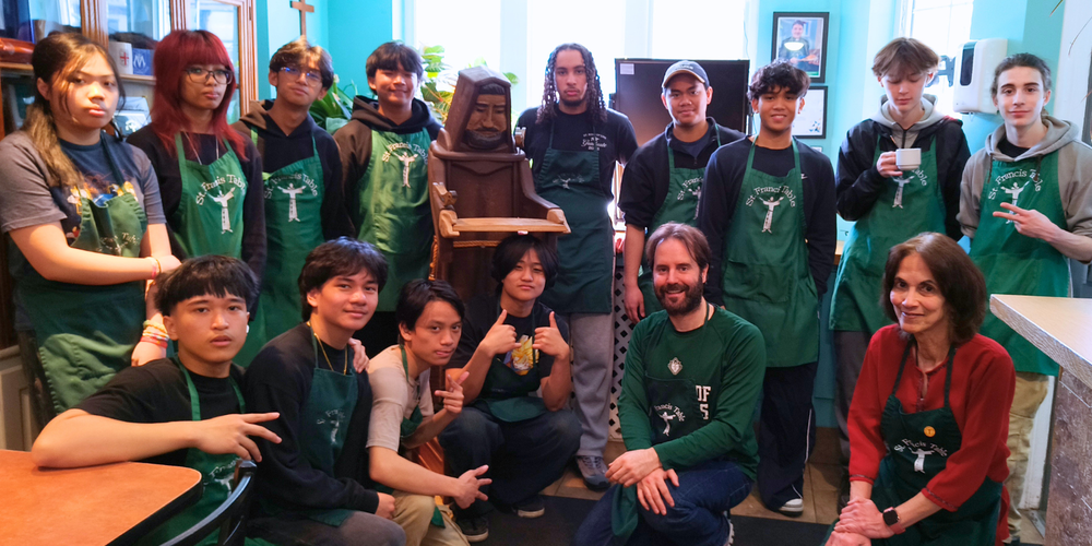 Group photo of students with green aprons on. 