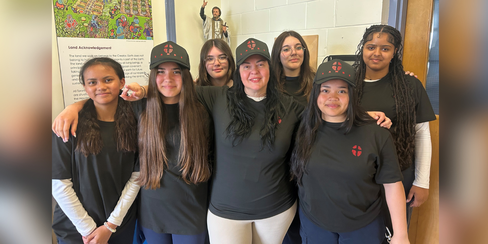 Students and faculty posing in black shirts.