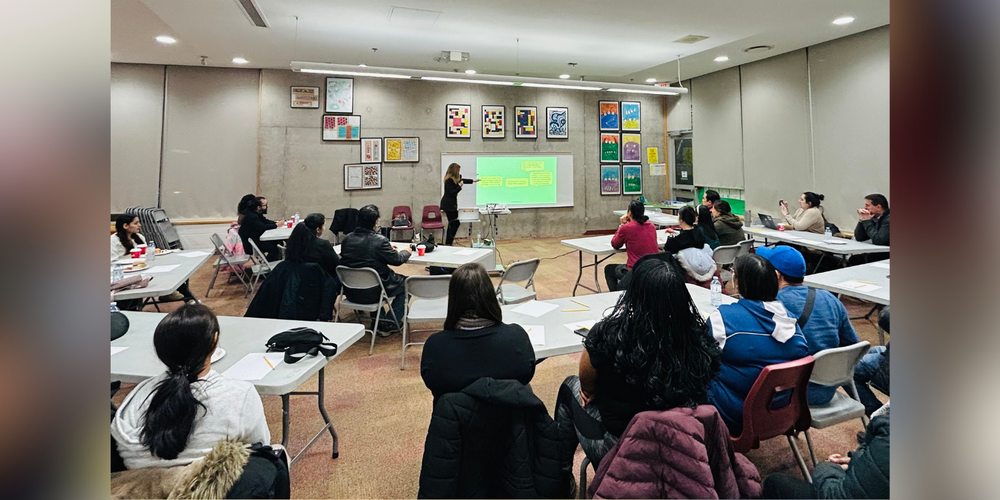 Adults watching someone give a presentation