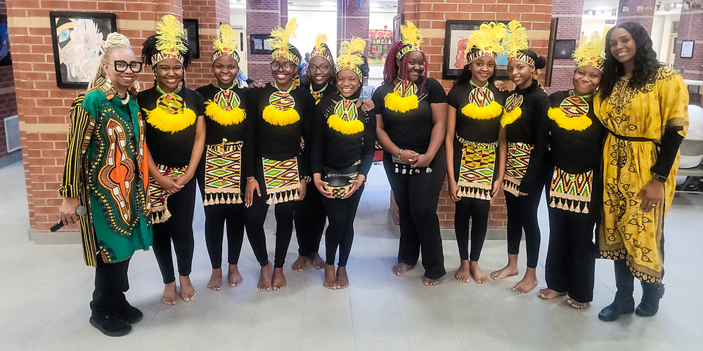 Group photo of students and staff in traditional attire