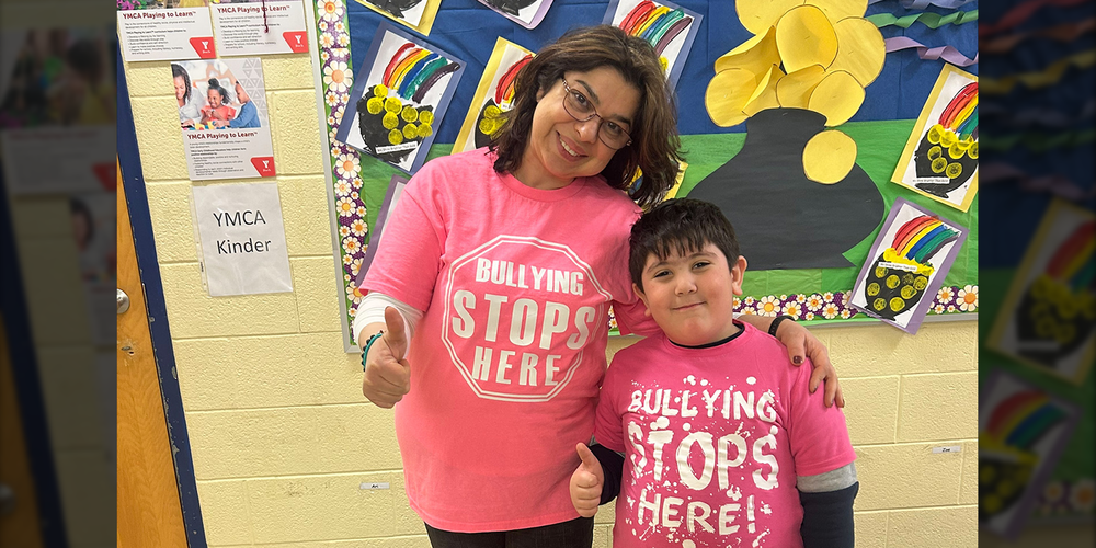 Photo of a teacher and a student wearing pink shirts against bullying for Pink Shirt Day