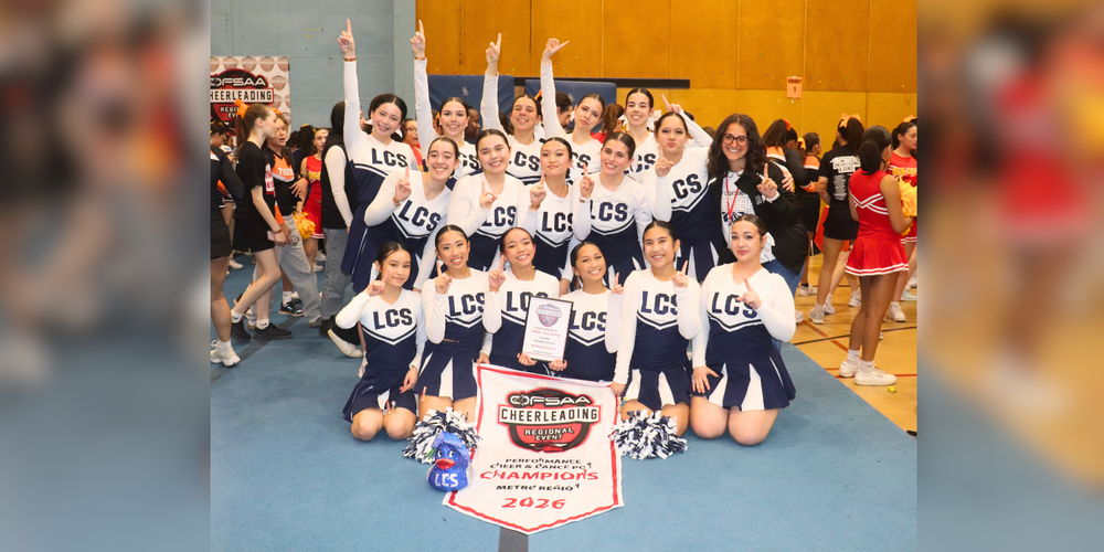 Cheerleader students posing with a 2026 Champions banner