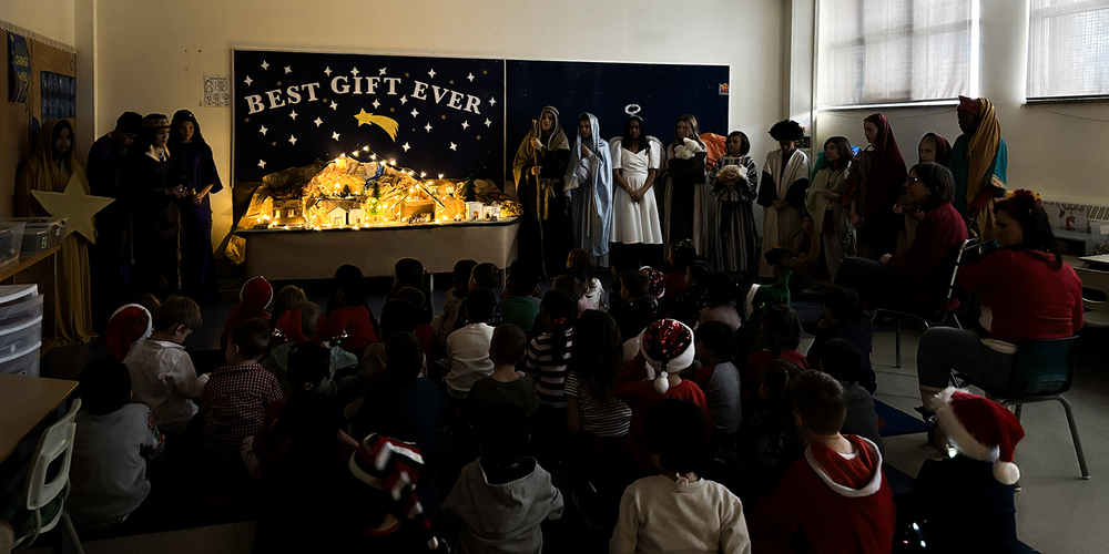 Photo of St. Brigid Grade 7 students presenting their Nativity Scenes in costume to the younger grades