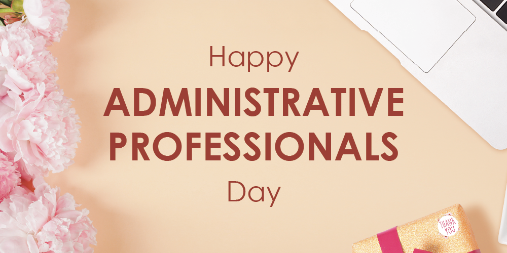 A beige graphic with the text “Happy Administrative Professionals Day,” decorated with pink flowers on the left, a laptop corner at the top right, and a small wrapped gift at the bottom right.