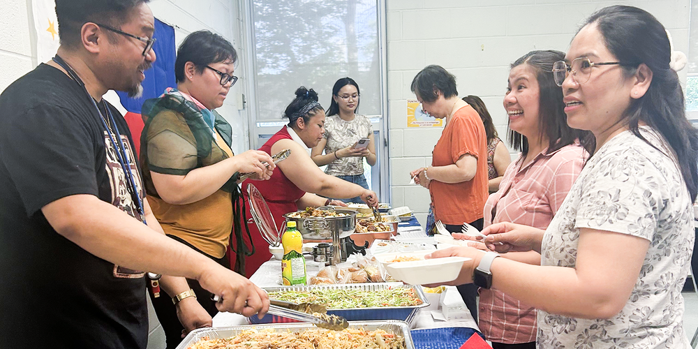 Photo of staff and organizers giving food to attendees at the festival